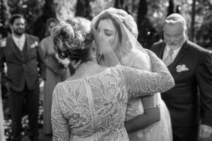 Bride kissing her mother after walking down the aisle during a ceremony at Ann Arbor City Club in Ann Arbor, Michigan